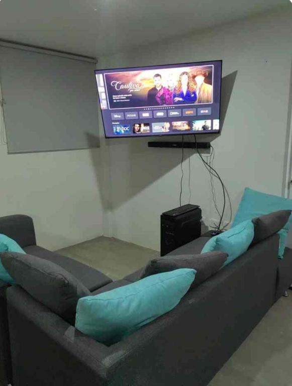 a living room with a couch and a flat screen tv at Departamento Atlixco in Atlixco