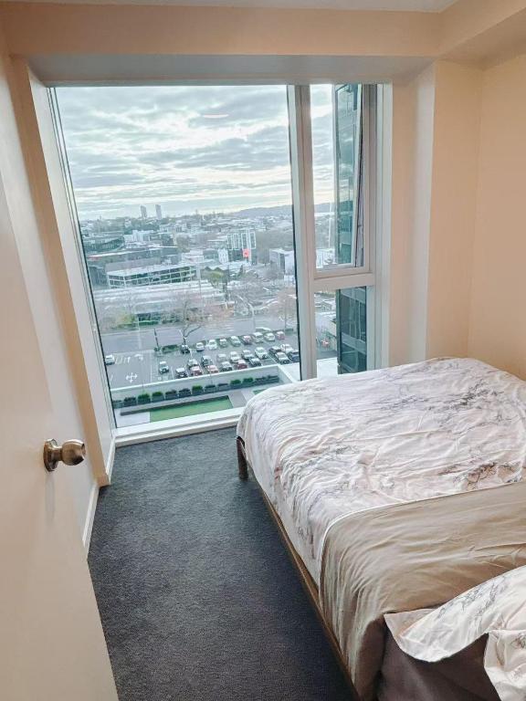 a room with a bed and a large window at Imperial Garden2 in Auckland