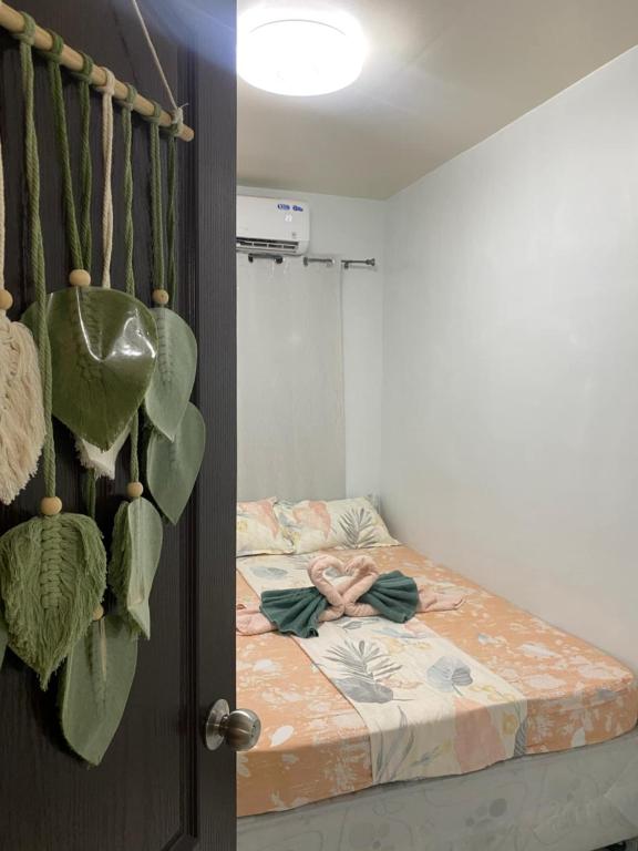 a bedroom with a bed with a large green plant at Mamsis Cozy Home by RH in Bangad