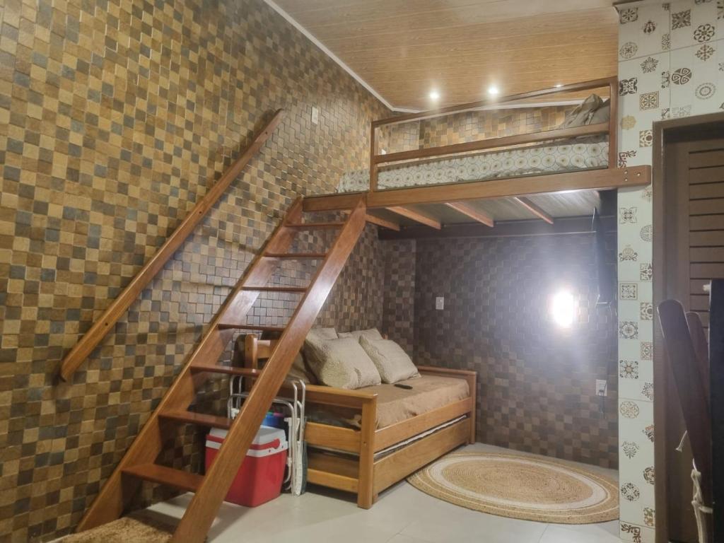 a small room with a bunk bed and a staircase at 09 Kitnet próximo da praia com ar-condicionado in Maceió