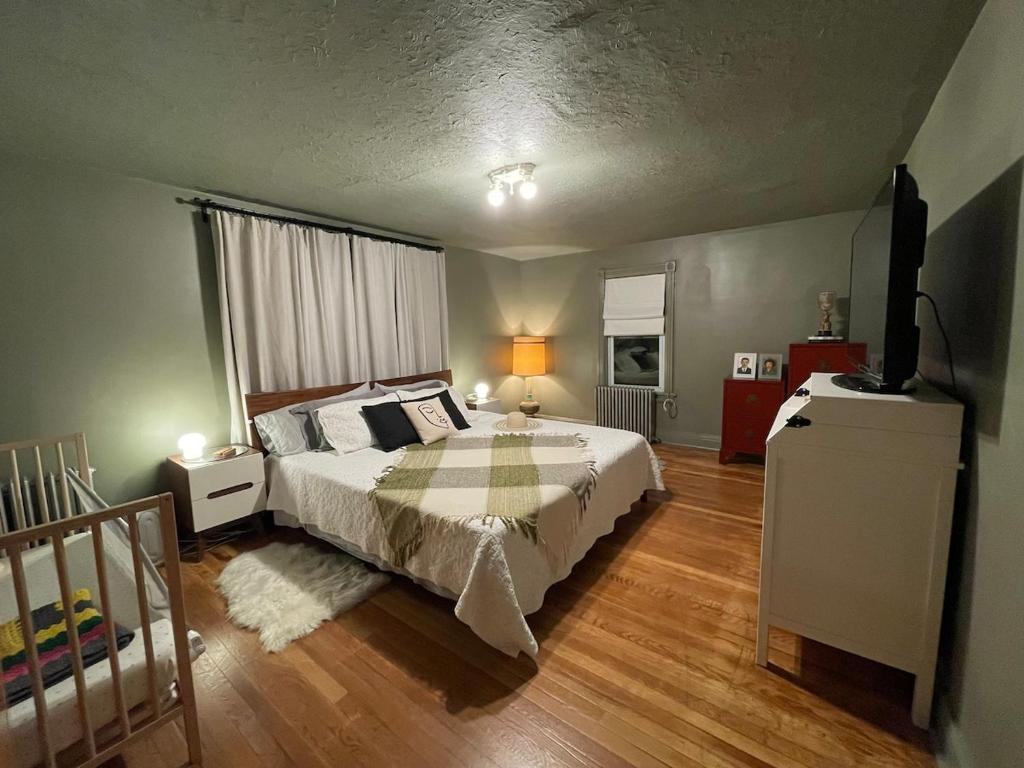 Un dormitorio con una cama y un televisor. en Twin Creeks, Waterfront Catskills Retreat, en Ellenville