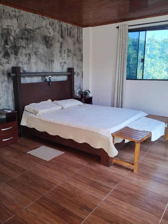 a bedroom with a large bed and a window at Recanto verde 3 in Alegrete
