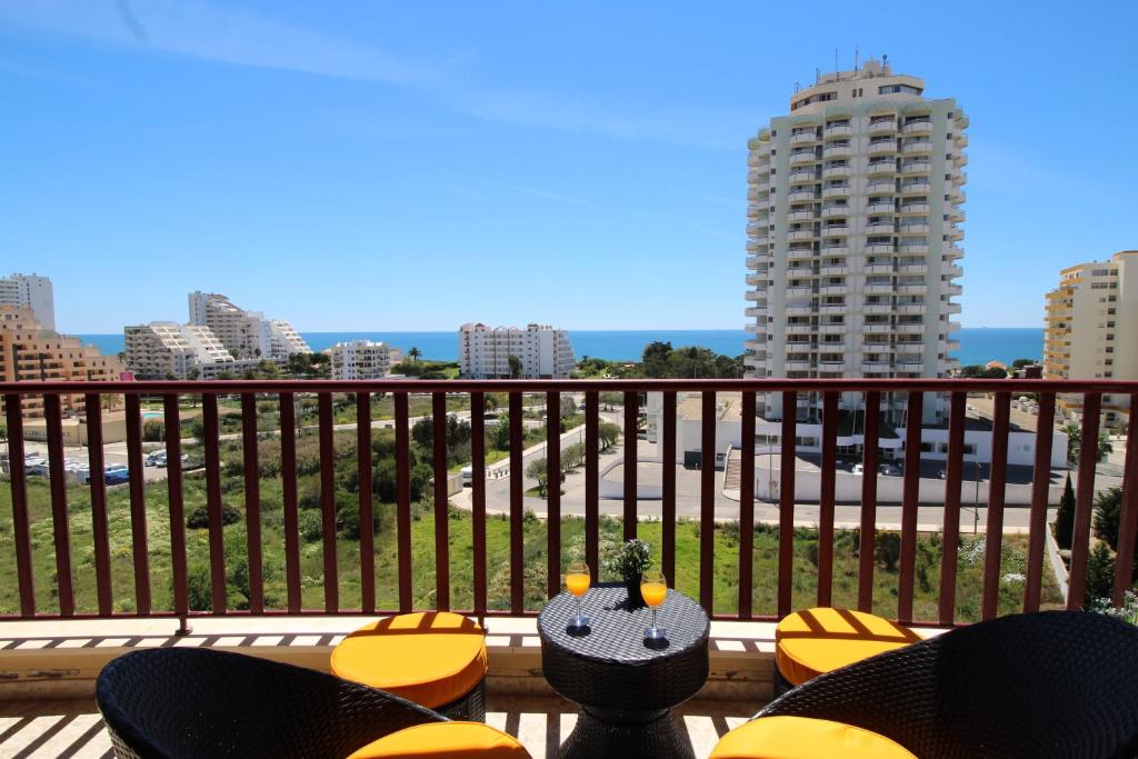 einen Balkon mit Stühlen und Stadtblick in der Unterkunft Club Praia Mar in Portimão