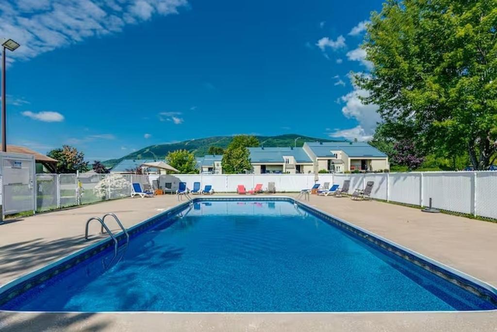 Una piscina con agua azul en un patio. en Le familial 9 personnes, en Beaupré