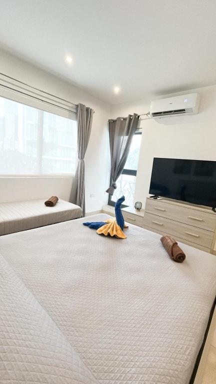 a bedroom with a large bed with a blue bird on it at 100m from Paceville Apartment in St. Julianʼs