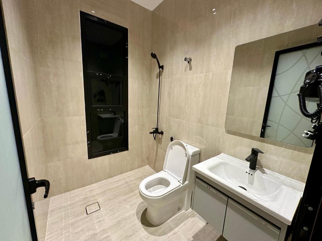 a bathroom with a toilet and a sink at شقة أنيقة بغرفتين نوم وصالة in Al Khobar