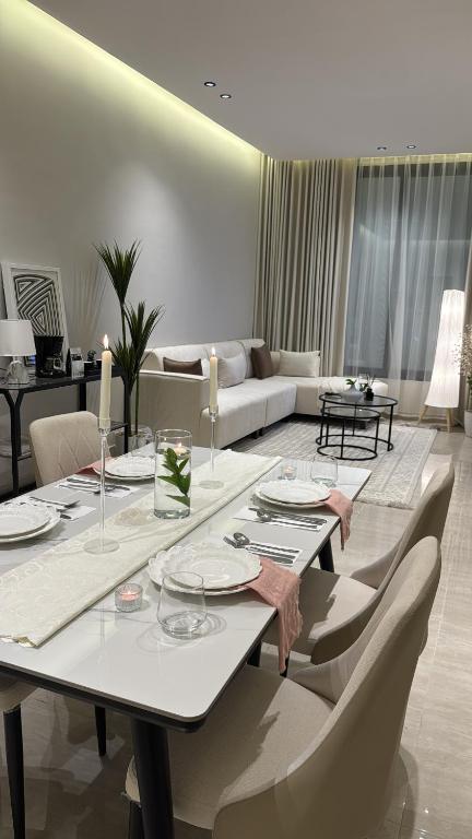 a living room with a table and a couch at شقة أنيقة بغرفتين نوم وصالة in Al Khobar