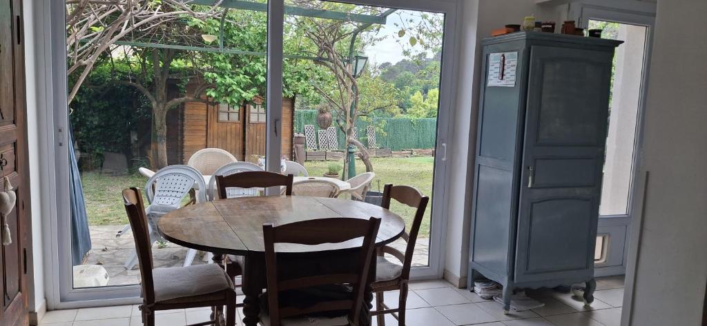 une salle à manger avec une table et des chaises et une fenêtre dans l'établissement rez de chaussée de villa, à La Colle-sur-Loup