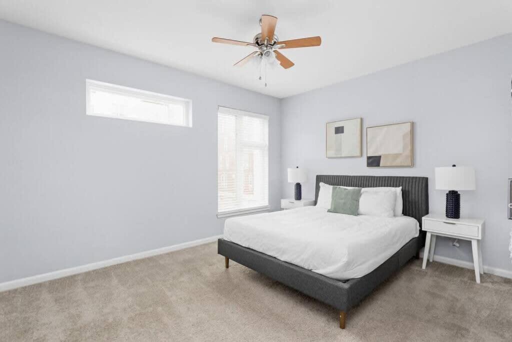 a white bedroom with a bed and a ceiling fan at CozySuites l Bold 1BR, Monument Circle, Indy in Indianapolis