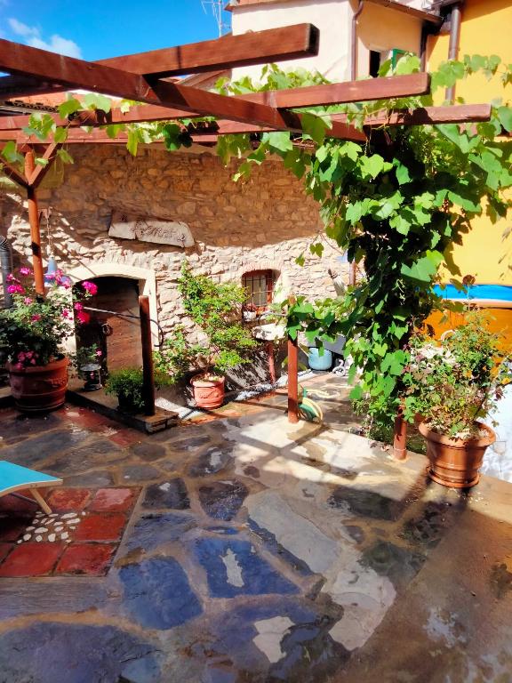 a patio with potted plants and a stone fireplace at A fenera in Dolcedo