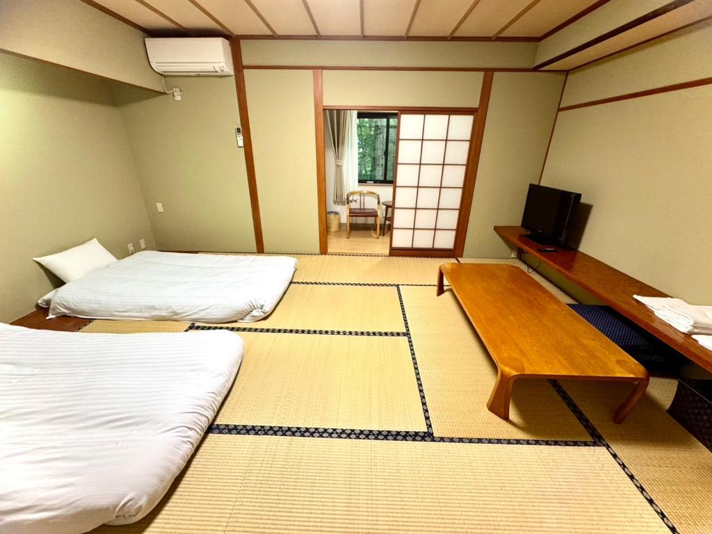 Postel nebo postele na pokoji v ubytování 富士たから荘 旭日館