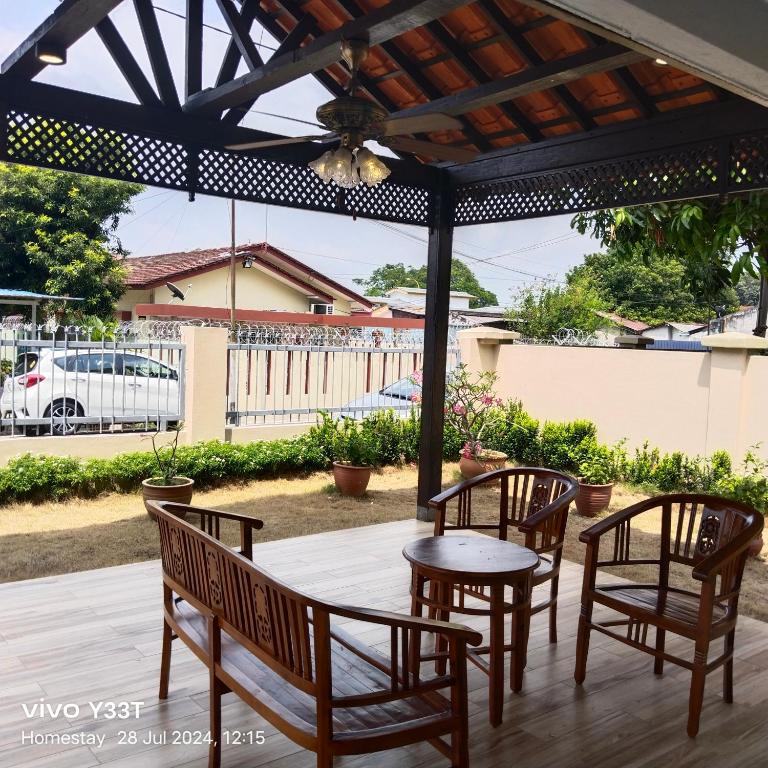 a patio with chairs and a table and a pergola at Homestay Klang in Klang