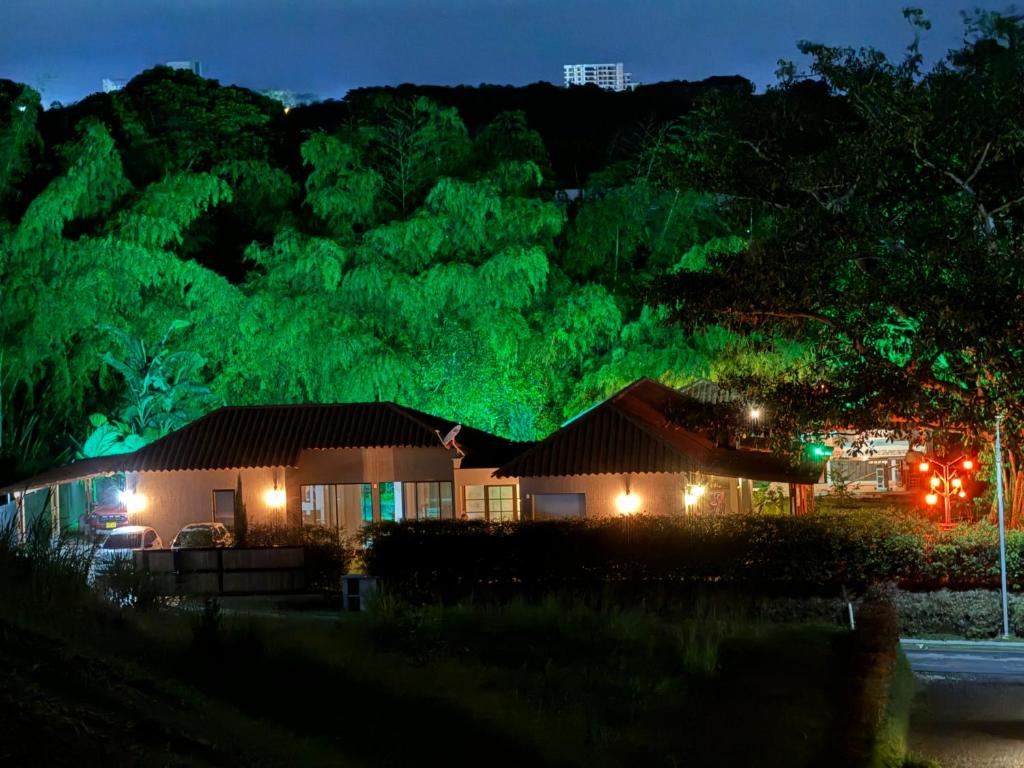 a house lit up at night with green lights at Entre Guaduales in Pereira
