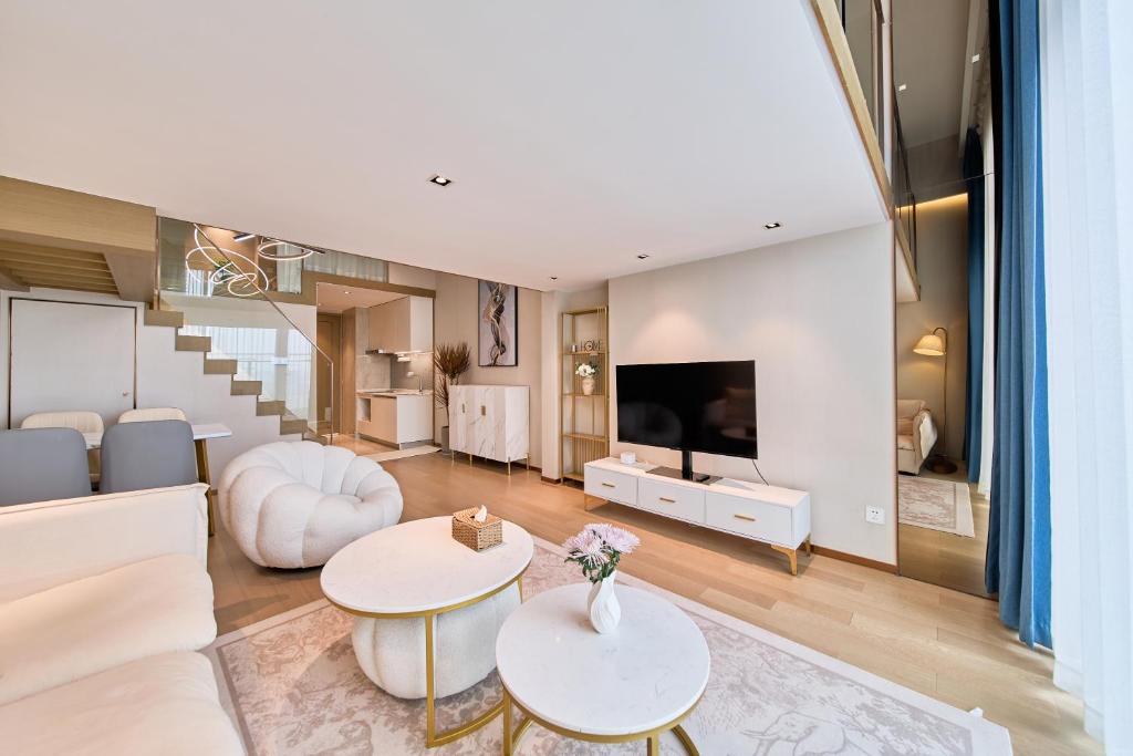 ein Wohnzimmer mit Sofa und Fernseher in der Unterkunft Yifang Apartment in Hangzhou