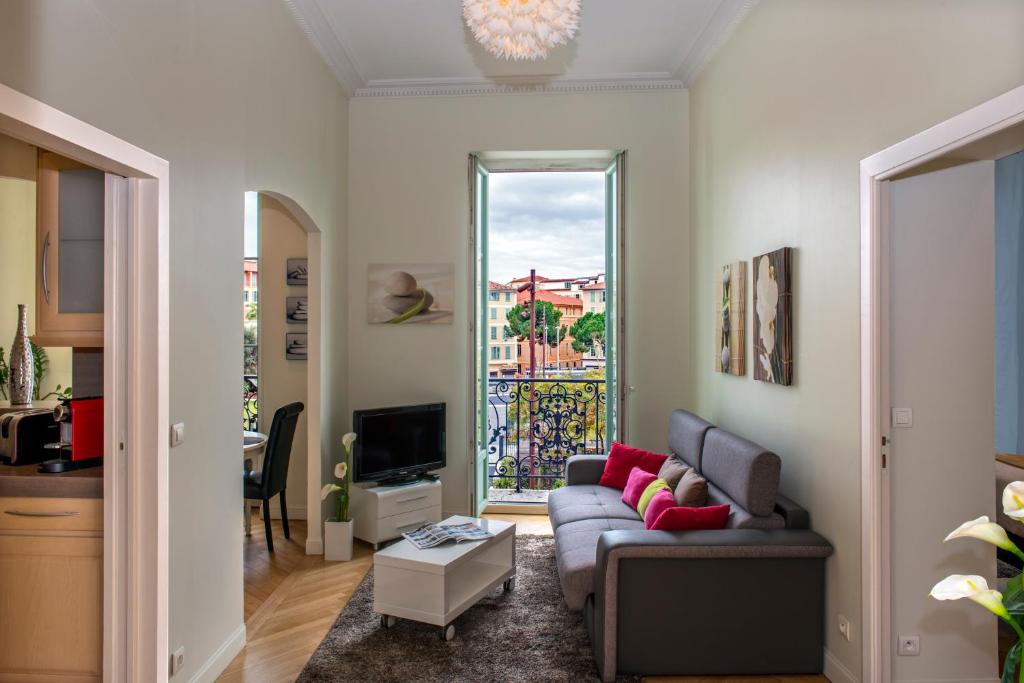 uma sala de estar com um sofá e uma televisão em Aston - Appartement Centre Ville Massena em Nice