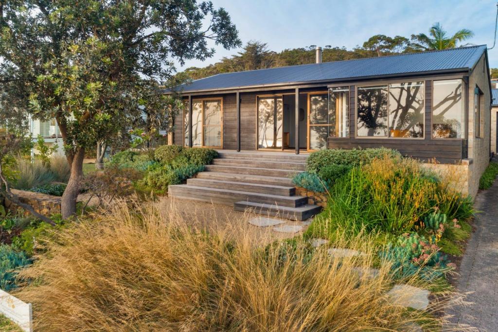 a house with a staircase leading up to it at Chinamans at Hyams Beach in Hyams Beach