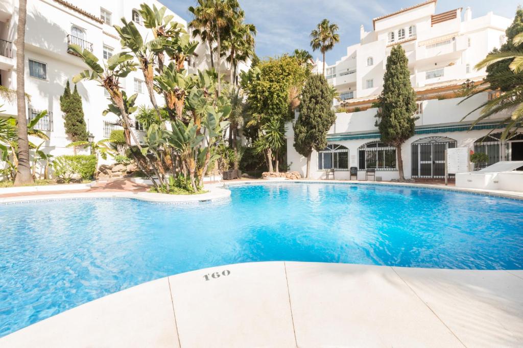 a swimming pool in front of a building at Apartamento Pueblo Quinta in Benalmádena