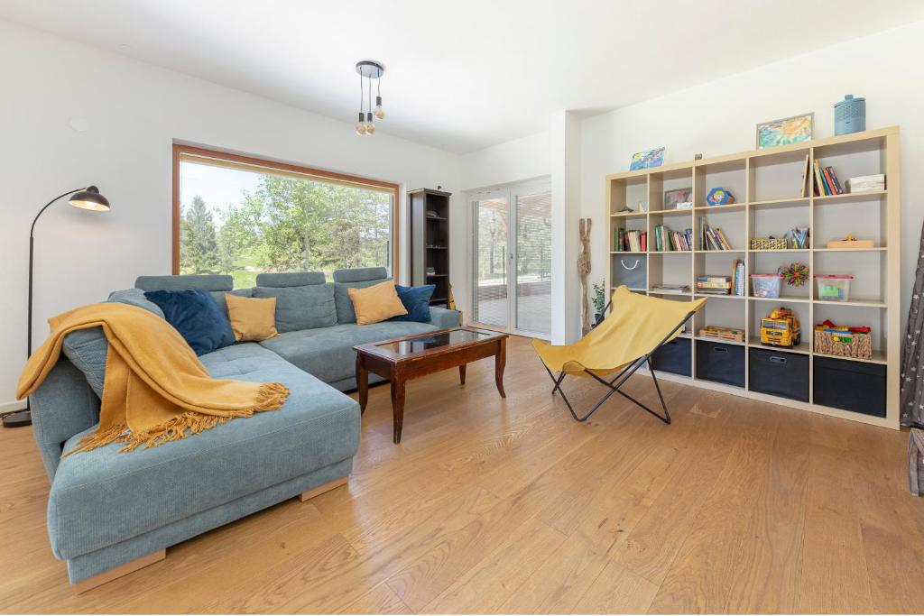 ein Wohnzimmer mit einem blauen Sofa und einem gelben Sessel in der Unterkunft Kurešček in Ig