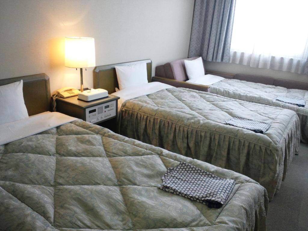Postel nebo postele na pokoji v ubytování Pulses Inn Kyoto