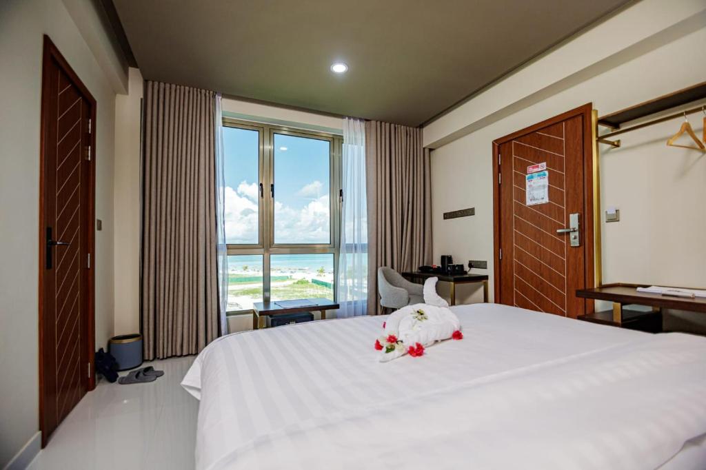 a bedroom with a large white bed with flowers on it at Royal Villa Fulidhoo in Fulidhoo