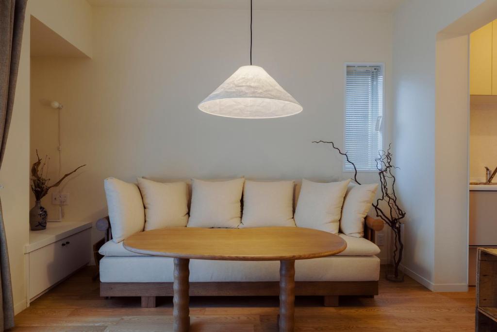 東京にあるThe Apartment Hotel 恵比寿1のソファとテーブルのあるリビングルーム