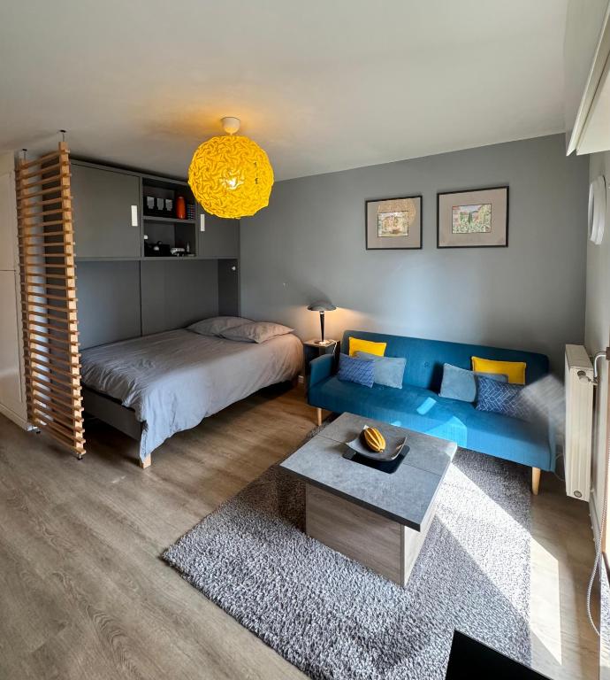 une chambre avec un lit et un canapé bleu dans l'établissement Studio 2 adultes 2 enfants parcs Disneyland Paris, à Montévrain