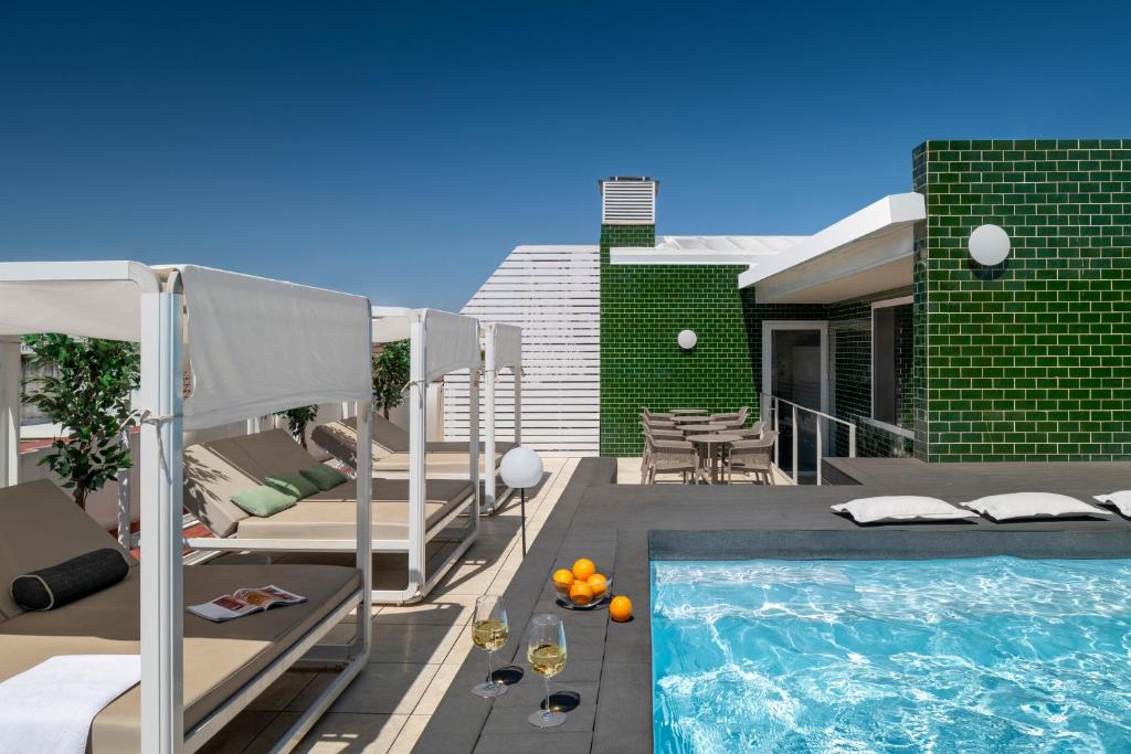Un patio trasero con piscina y una casa. en Ópera Apartments Alameda, en Sevilla