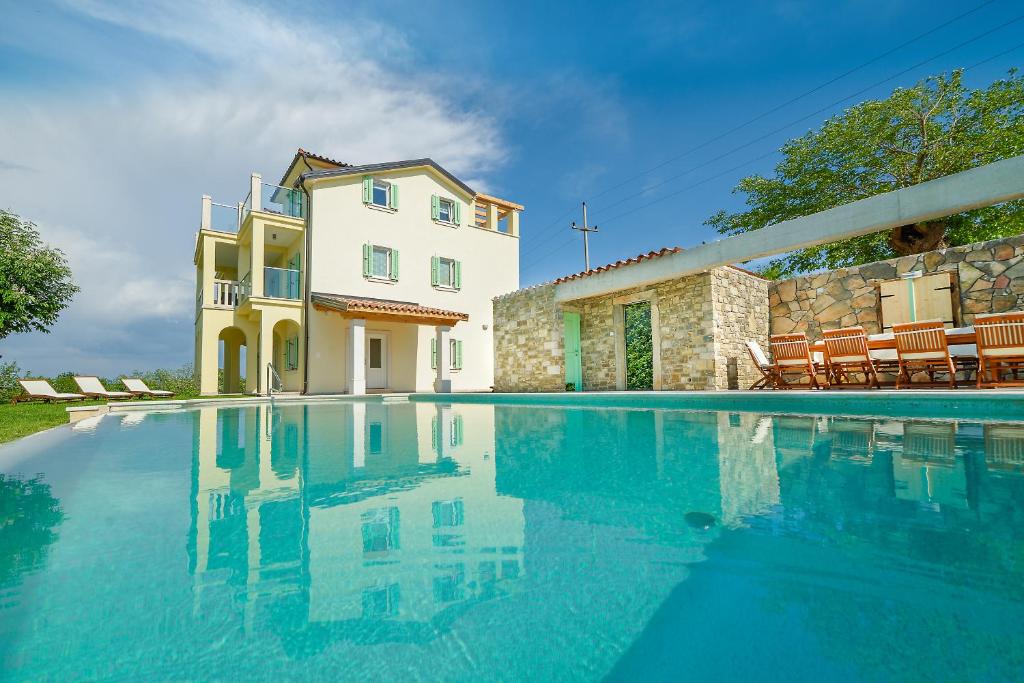 a swimming pool in front of a house at Villa Demetra in Motovun