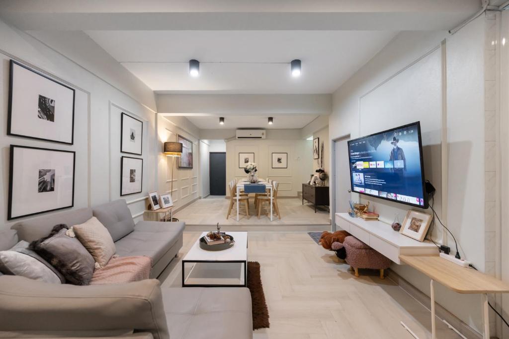 Una sala de estar con un sofá y un televisor. en 4BR house MRT subway 250m Chatujak Market wi-fi, en Bangkok