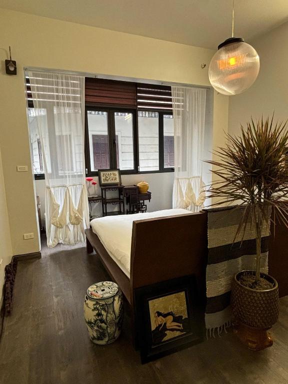 a bedroom with a large bed and a potted plant at April twelve in Hanoi