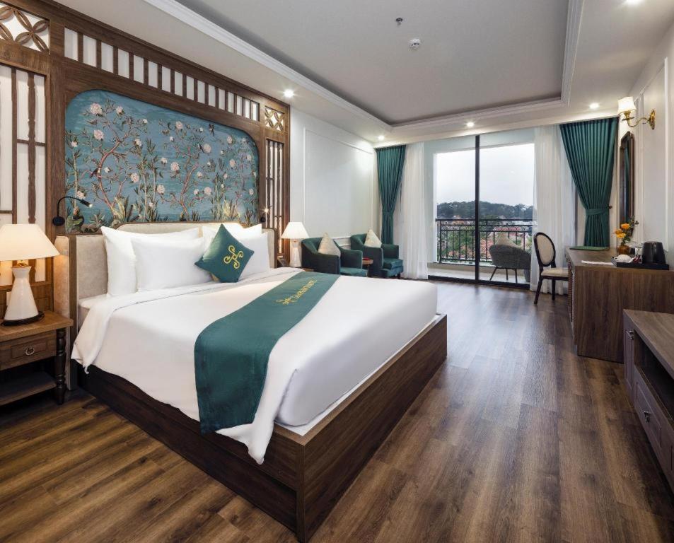 ein großes Schlafzimmer mit einem großen Bett und einem Schreibtisch in der Unterkunft Da Lat Prince in Khu Chi Lăng