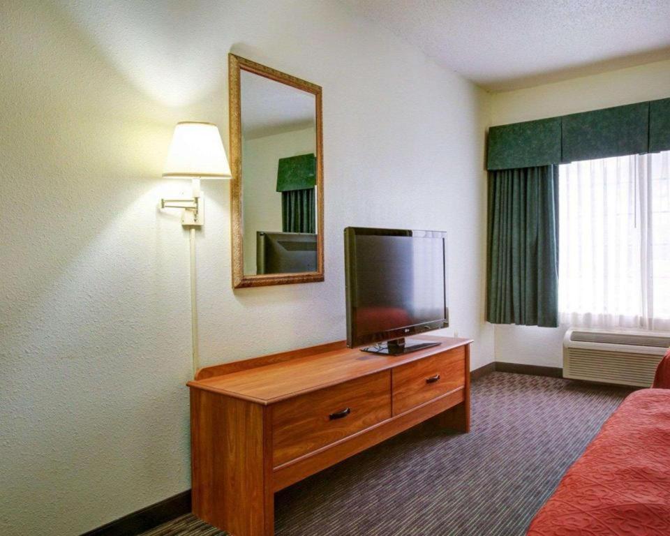 a hotel room with a flat screen tv on a dresser at Quality Inn & Suites Airport in Austin