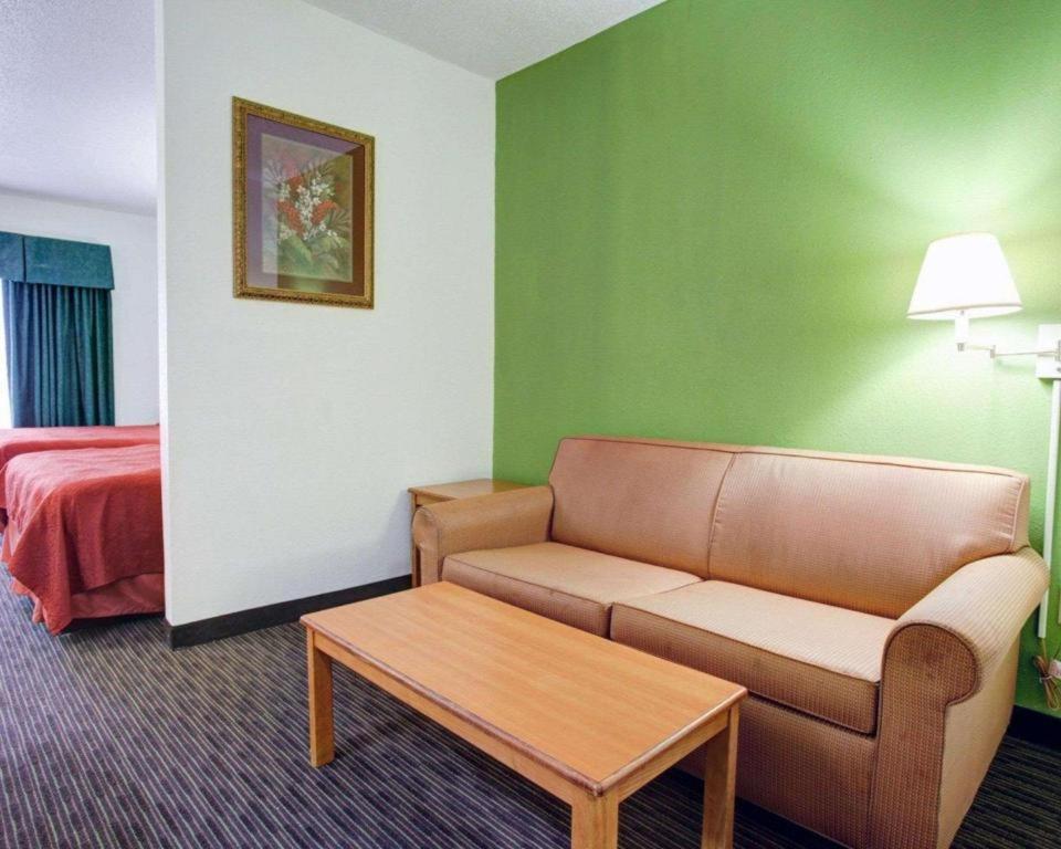 a living room with a couch and a table in a hotel room at Quality Inn & Suites Airport in Austin