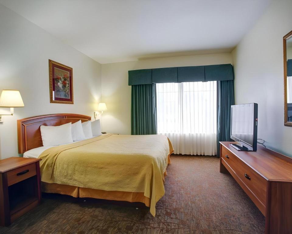 a hotel room with a bed and a television at Quality Inn & Suites Airport in Austin