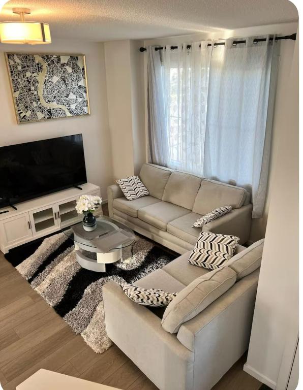 a living room with a couch and a tv at Bedroom in Southwest 2 in Edmonton