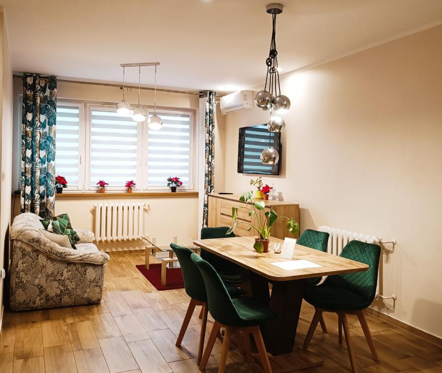 a dining room with a table and green chairs at Pokoje gościnne Jola in Drawsko Pomorskie