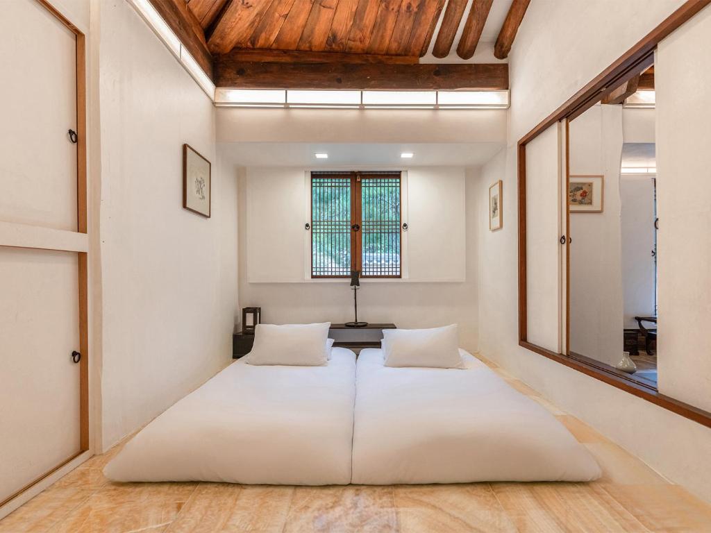 Postel nebo postele na pokoji v ubytování Rakkojae Hahoe Hanok Hotel