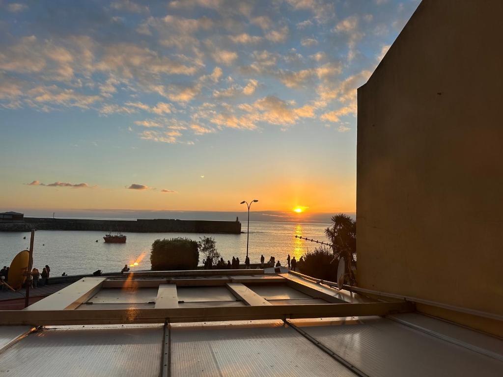 a sunset from a building with a view of the water at Malteses in A Guarda