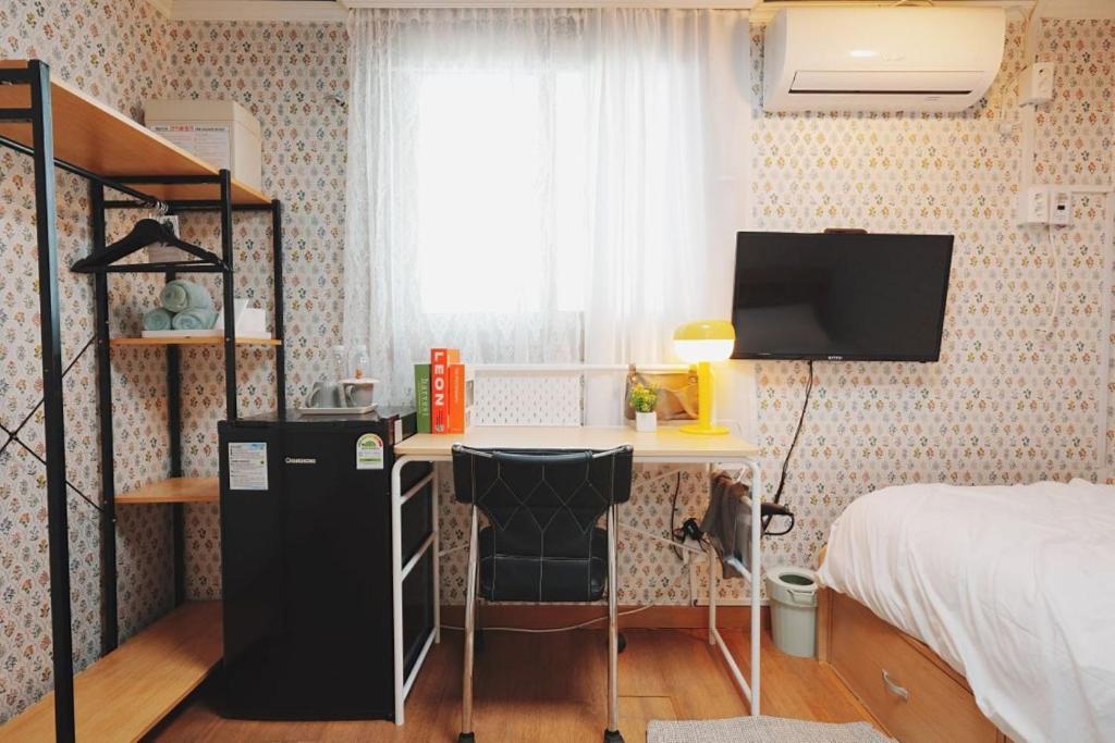 Dormitorio con escritorio, cama y TV en 레토하우스, en Incheon