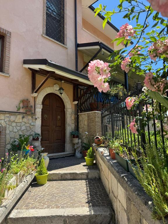 a house with a wooden door and a fence at Affittacamere Villa Rosa in Pacentro