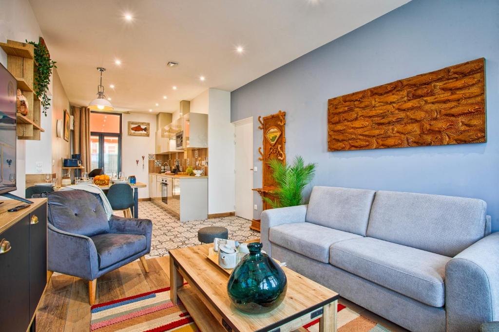 a living room with a couch and a table at VILLA 139 LA VAGUE - FRONT DE MER - appartement contemporain et terrasse sur cour - 2 à 6 personnes - Rez-de-chaussée in Houlgate