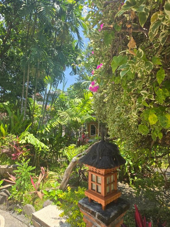 a small bird house in a garden at Rambutan Hotel in Lovina