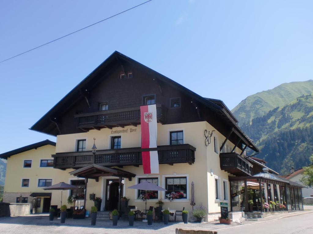 a large building with a red ribbon on it at Hotel - Landgasthof Post in Bichlbach