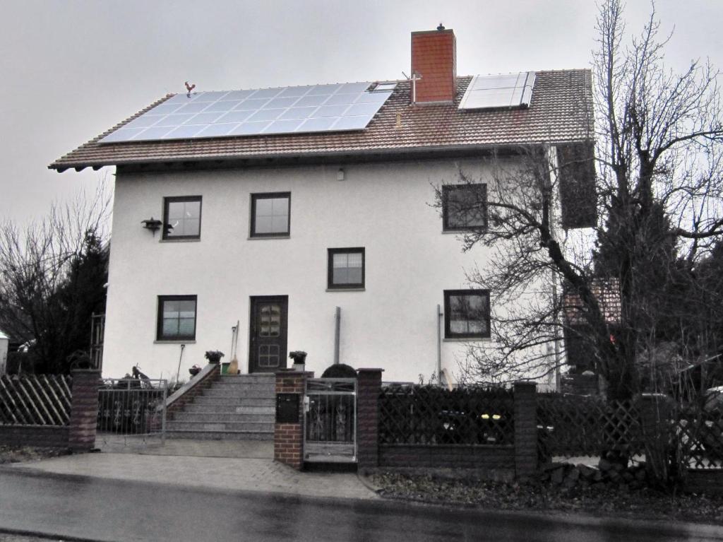 een wit huis met zonnepanelen op het dak bij Separatè im Haus Carmen in Schrebitz