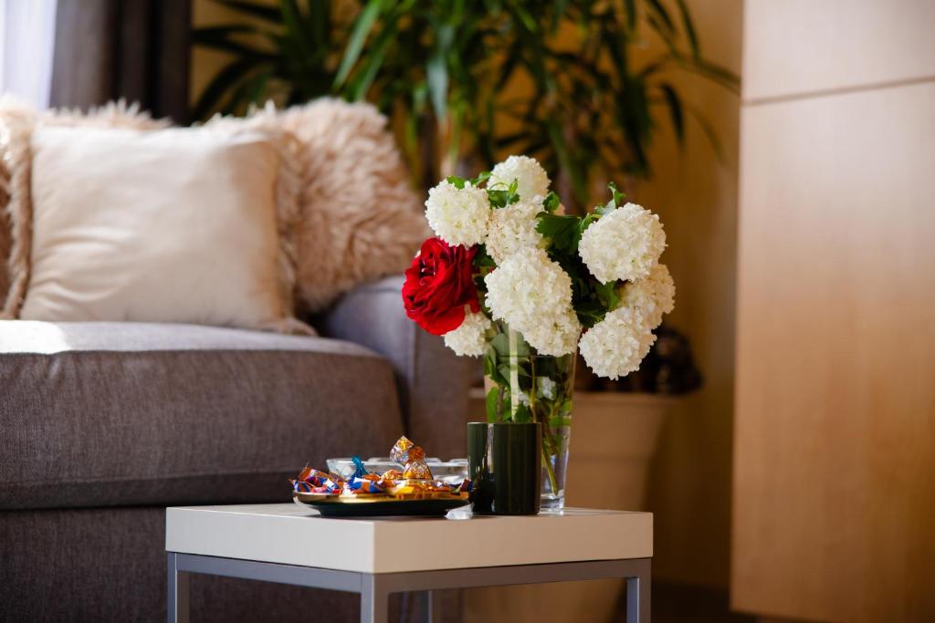 a vase with red and white flowers on a table at Kuća za odmor Mia 