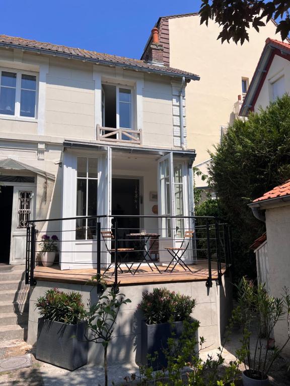 Cette maison dispose d'un balcon avec une table et des chaises. dans l'établissement Lofoten, à Le Touquet-Paris-Plage