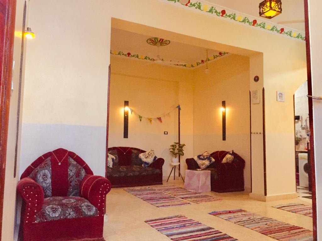 a living room with two chairs and a mirror at sun smile guest house᭄ꦿ in Luxor