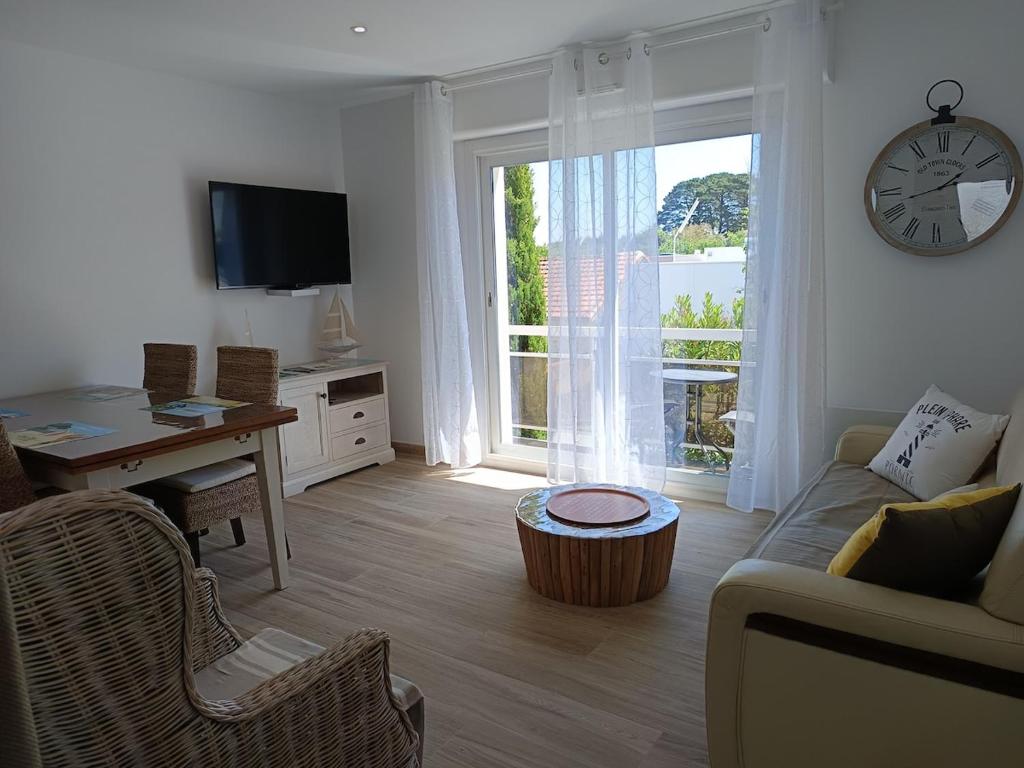 - un salon avec un canapé, une table et un réveil dans l'établissement Appartement cosy avec parking proche vieux port, à Pornic
