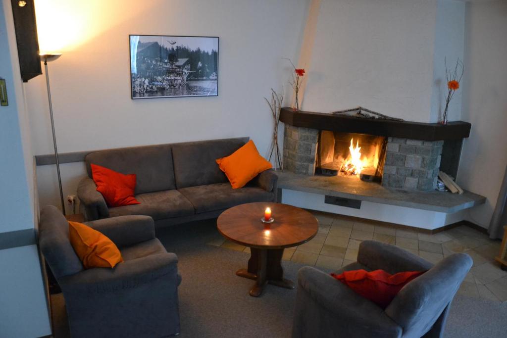 ein Wohnzimmer mit einem Sofa und einem Kamin in der Unterkunft Arcula in Flims