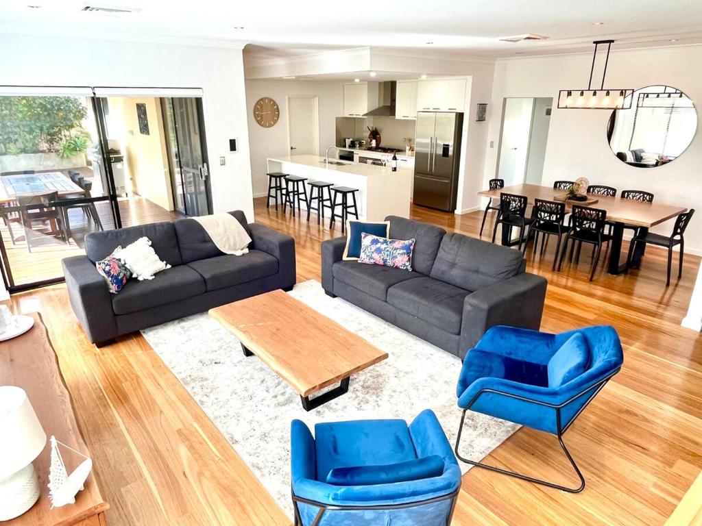 een woonkamer met een bank, stoelen en een tafel bij Royal-Tee Retreat in Dunsborough